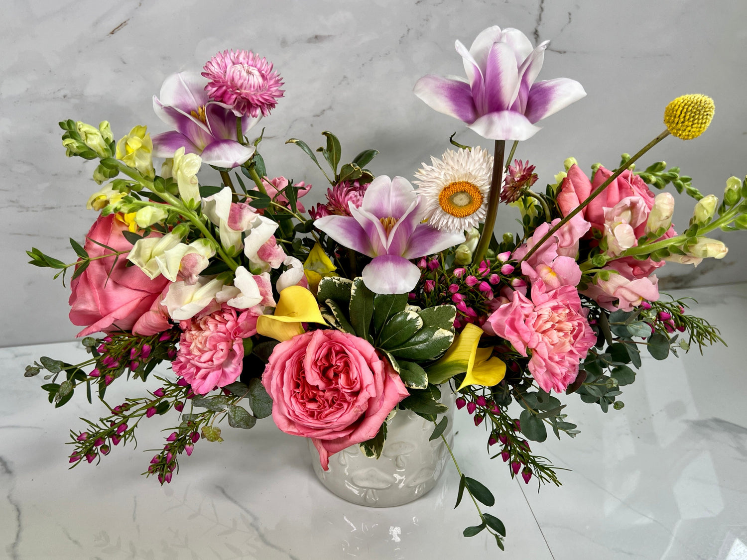 Bouquet of flowers in a clear vase on a marble surface